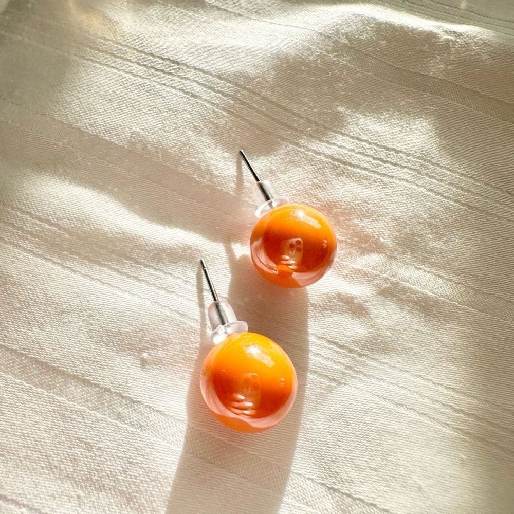 Glossy light orange stud earrings